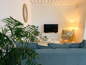 sala de estar con sofá azul y TV en Cooly Coastal Escape walk to beach & shops en Gold Coast
