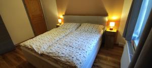una camera da letto con un letto con due lampade su entrambi i lati di Fuchsbauerhof - Ferienwohnung 