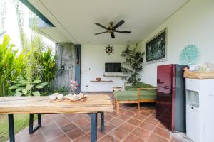a living room with a table and a couch at The Kumpi Bali by The Lavana in Canggu