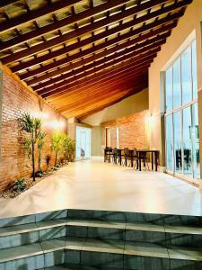 オルトランジアにあるPrime Hotel Hortolândiaの木製の天井、テーブルと椅子が備わる広い客室です。