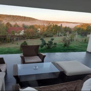 a patio with a table and chairs and a view of a field at Rózsadomb apartman in Bogács