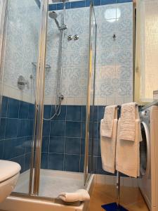 y baño con ducha de azulejos azules. en Villa Claudia, en SantʼAgata sui Due Golfi