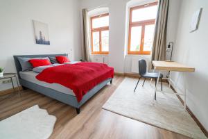 1 dormitorio con cama con almohadas rojas y escritorio en FullHouse - Görlitz - B7 Bruno - 3 Bedrooms, en Görlitz