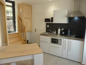 a kitchen with white cabinets and a counter top at Logis Auberge de l'Isard in Saint-Lary