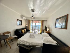 a bedroom with a large bed and a couch at LE CONSTELLATION AP4333 By Riviera Holiday Homes in Juan-les-Pins