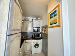 a small kitchen with a washing machine and a microwave at LE CONSTELLATION AP4333 By Riviera Holiday Homes in Juan-les-Pins
