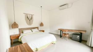 a bedroom with a bed and a wooden table at The Kumpi Bali by The Lavana in Canggu