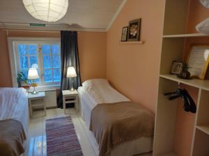 1 dormitorio con 2 camas, escritorio y ventana en Brobacka Gästhem, en Jomala