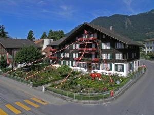 een groot gebouw met een tuin ervoor bij Hotel Chalet Swiss in Interlaken
