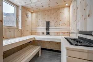 a sauna with wooden walls and a window and benches at Falkners Five in Oetz