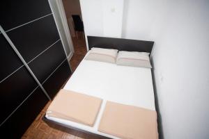 een klein wit bed in een kleine kamer bij Apartments Pavic in Jesenice