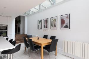 une salle à manger avec une table en bois et des chaises noires dans l'établissement Stunning double bedroom in 4 bedroom house in Peckam, à Londres