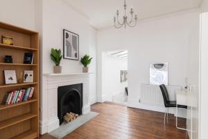 a white living room with a fireplace and a desk at Stunning double bedroom in 4 bedroom house in Peckam in London