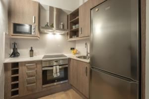 uma cozinha com um frigorífico de aço inoxidável e um lavatório em El Racó em Camprodon