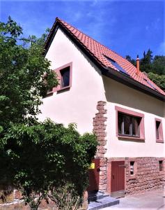 uma casa branca com um telhado vermelho em Ferienhaus In der Erlebach em Elmstein