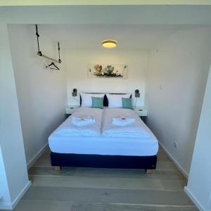 ein Schlafzimmer mit einem Bett mit zwei Handtüchern darauf in der Unterkunft Großzügige FeWo mit Bergblick am Tegernsee in Bad Wiessee