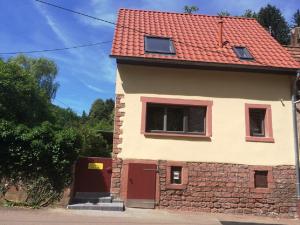 uma casa com telhado vermelho e portas vermelhas em Ferienhaus In der Erlebach em Elmstein