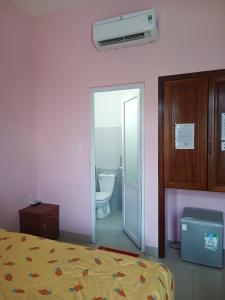 Phương Trang Hotel Vũng Tàu في فنغ تاو: غرفة نوم بسرير وحمام مع مرحاض