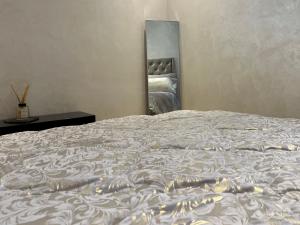 a large bed in a bedroom with a mirror at Cosy & Quiet Expat Studio in Kenitra +9 photos