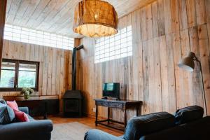 a living room with a couch and a television in a room at LAS ACACIAS Casa rural en el campo in San Poncio