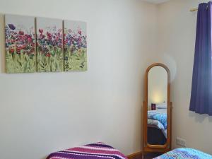 a bedroom with a mirror and a bed at Acorn Cottage in Cononbridge