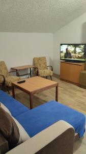 een woonkamer met een tv en een tafel en stoelen bij Apartmán U Švejdy in Skuhrov nad Bělou