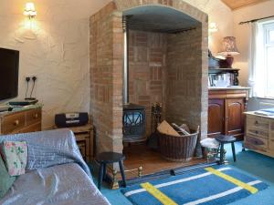 a living room with a brick fireplace and a couch at Mickrandella in Martham