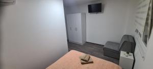 Pokój z łóżkiem, telewizorem i krzesłem w obiekcie Apartmani Hani w mieście Trebinje