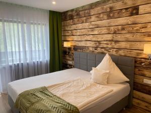 a bedroom with a bed with a wooden wall at Gasthof zur Sonne Winzenhohl in Hösbach