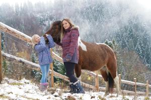 a woman and a child standing next to a horse at Górna Chata Mountains Chalet - Stable Cottage in Ochotnica Górna