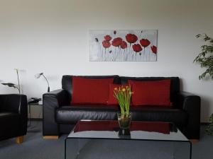 a living room with a black couch and red pillows at Haus Fernblick in Badenweiler