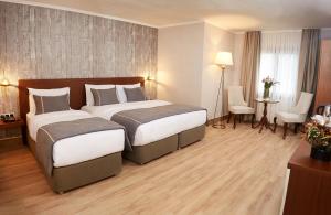 Habitación de hotel con 2 camas, mesa y sillas en Mira Otel Alsancak en İzmir