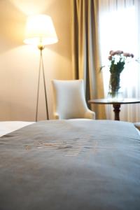 um quarto de hotel com uma cama, uma mesa e um candeeiro em Mira Otel Alsancak em Esmirna