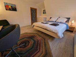 um quarto com uma cama e uma cadeira em Gemütliche Zimmer im Herzen der Stadt EM-APARTMENTS DEUTSCHLAND em Bielefeld