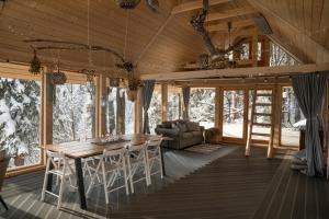 a living room with a wooden table and chairs at Górna Chata Mountains Chalet - Stable Cottage in Ochotnica Górna +190 photos