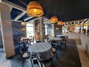 jadalnia ze stołami, krzesłami i oświetleniem w obiekcie Green Point Apartment Kołobrzeg w Kołobrzegu