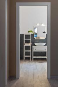 La salle de bains est pourvue d'un lavabo et d'un miroir. dans l'établissement The Olive Grove in Tuscany, à Toiano