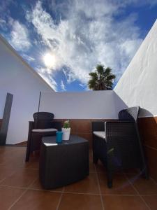 d'un balcon avec deux chaises, une table et un ciel. dans l'établissement Apartamento Catayfa, à Teguise