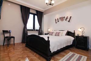 um quarto com uma cama preta e uma janela em Istoric Center - Romanian Quiet Apartment em Bucareste