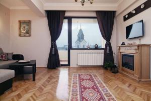 uma sala de estar com lareira e uma grande janela em Istoric Center - Romanian Quiet Apartment em Bucareste