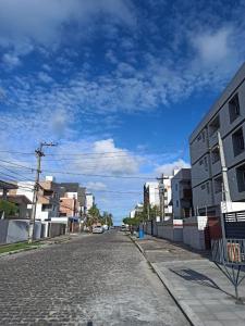 una calle vacía en una ciudad con un cielo azul en FLAT - 200m da orla do Bessa, en João Pessoa