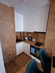 a kitchen with white cabinets and a black oven at Jahorina Woods - na stazi, ski-to-door in Jahorina +9 photos
