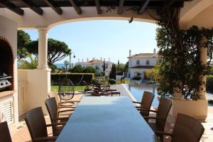 a table and chairs on a patio with a pool at Dunas Douradas Beach Club in Vale do Lobo