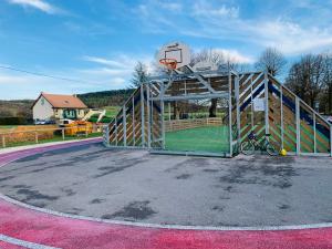 una cancha de baloncesto con un aro y un aro de baloncesto en Gîte « Au petit Bonheur » en Orges