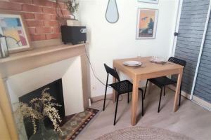 une salle à manger avec une table et une cheminée dans l'établissement Duplex Canal du Midi, à Toulouse