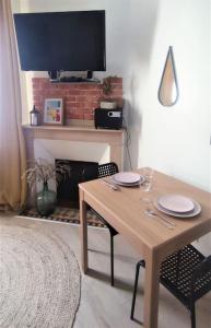 une table à manger avec deux chaises et une télévision dans l'établissement Duplex Canal du Midi, à Toulouse