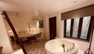 a bathroom with a tub and a dining room with a table at Moonlight Champa Riverview in Luang Prabang +160 photos