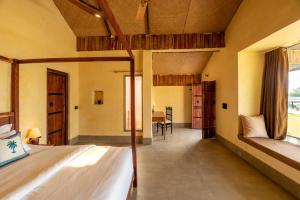 a bedroom with two beds and a dining room at 1br Cottage with Pool - Lake Escape by Roamhome in Udaipur