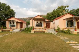 a row of houses with a yard at 1br Cottage with Pool - Lake Escape by Roamhome in Udaipur