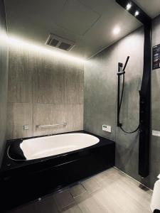 a bathroom with a large tub and a shower at House Hotel Kenrokuzaka in Kanazawa